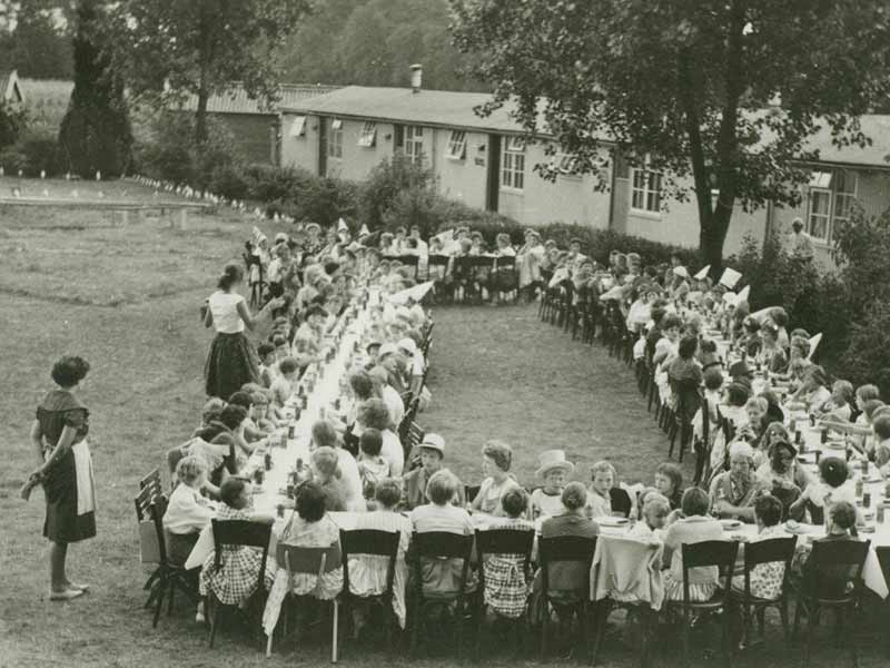 Old photo of children eating at a large table