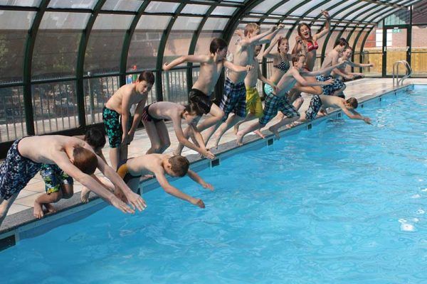 Group diving into swimming pool